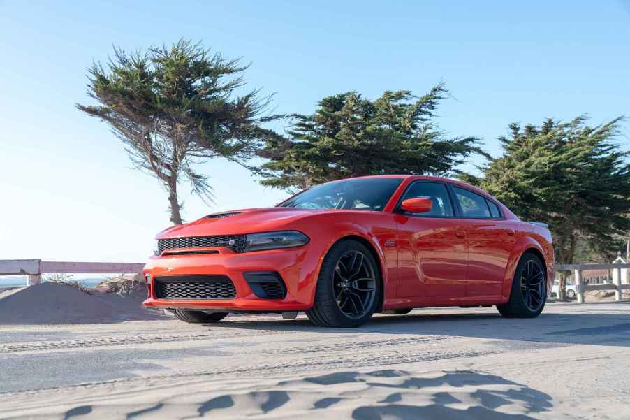 A red 2022 Dodge Charger Scat Pack Widebody driving near beach in left side angle view