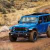 The 2024 Jeep Wrangler 4xe off-roading on a muddy road