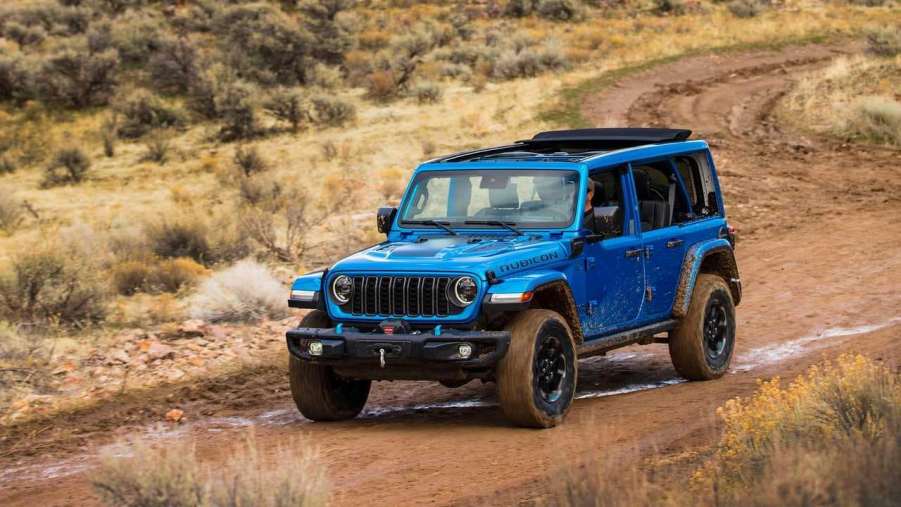 The 2024 Jeep Wrangler 4xe off-roading on a muddy road