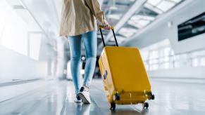 Airline passengers like this one with her rolling luggage are angry about rising costs and lost bags.