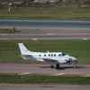 A Beechcraft King Air 90 series landing on a runway