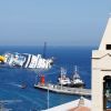 The shipwreck of the Costa Concordia off the coast of Italy, a church steeple in the foreground.