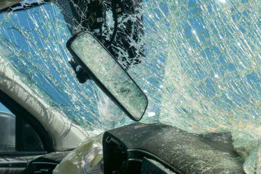 A crashed car displays its windshield and lack of standard safety features.