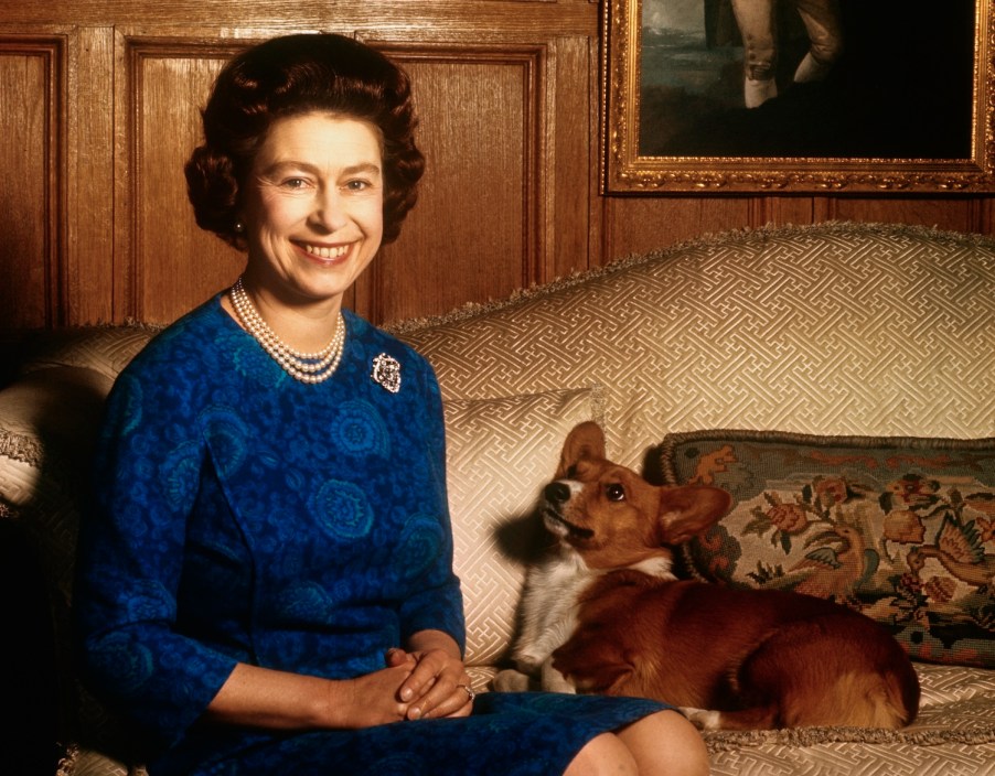 Queen Elizabeth II sitting with a corgi