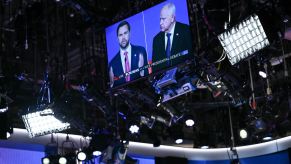 A monitor on the U.S. 2024 Vice Presidential debate stage shows both candidates, Governor Tim Walz and Senator J.D. Vance.