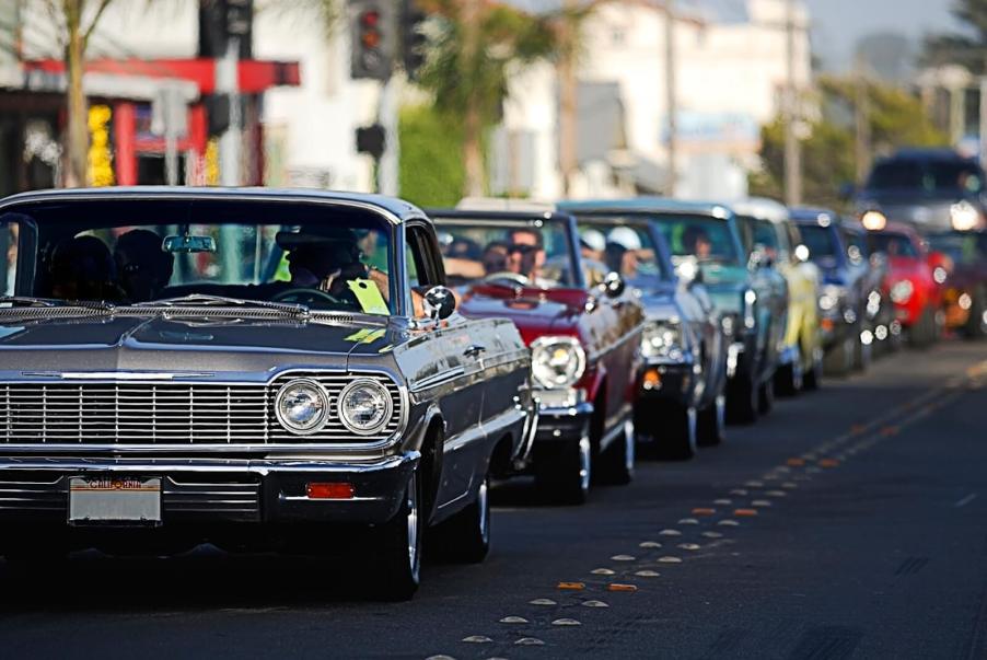 A car cruise with lowrider and classic car builds on city streets.