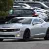 A charcoal Chevrolet Camaro two-door coupe sports car in a parking lot with fog lights illumunated