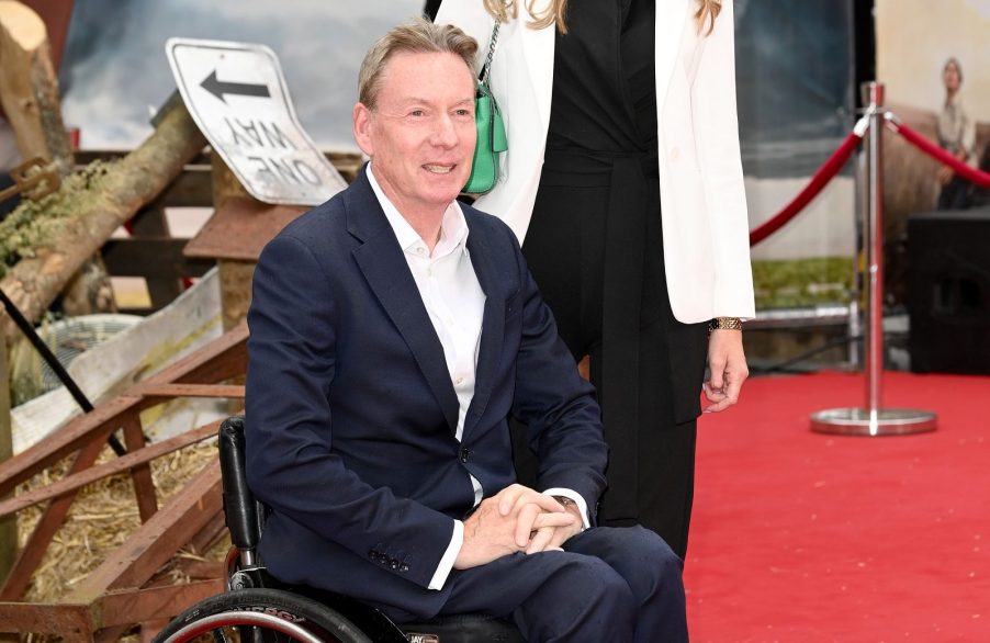 Frank Gardner dressed in a suit attending the European premier of the movie "Twisters" poses on the red carpet