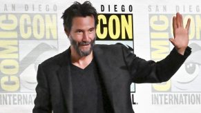 Keanu Reeves dressed in black waving in front of 2024 San Diego International Comic-Con banner in July 2024